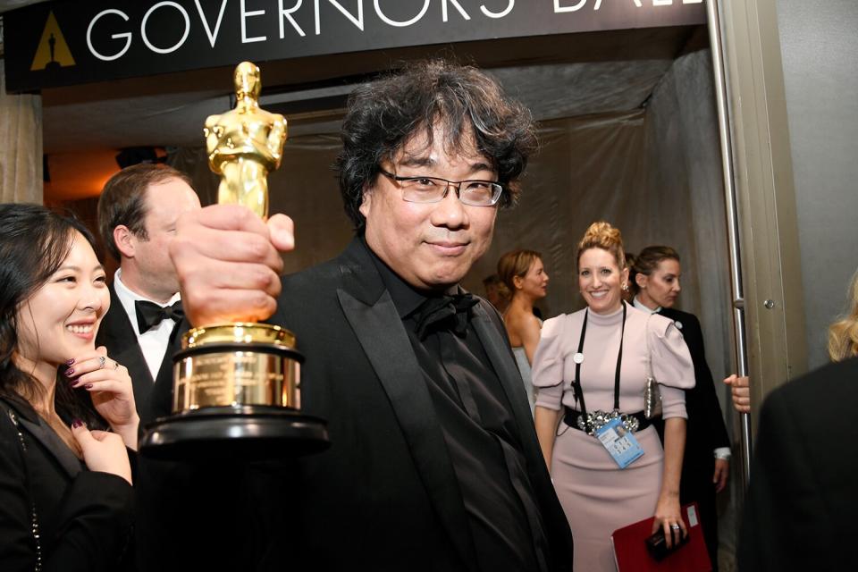 Writer-director Bong Joon Ho shows off one of his four Oscars, which he won for Best Picture, Director, Original Screenplay, and International Feature Film for <em>Parasite</em>. (And he actually apologized to the engravers for having so many to personalize!)