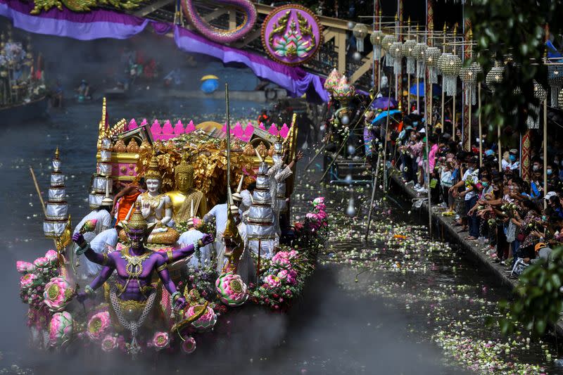 Budistas arrojan flores de loto hacia una estatua de Buda mientras asisten al festival de la flor de loto, para marcar el final de la cuaresma budista, en Samut Prakan, Tailandia