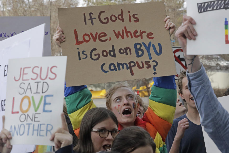 FILE - A protester joins several hundred students gathered near The Church of Jesus Christ of Latter Day Saints church headquarters on March 6, 2020, in Salt Lake City, to show their displeasure with a letter that week that clarified that "same-sex romantic behavior" is not allowed on campus at BYU. The U.S. Department of Education has opened a civil-rights investigation into how LGBTQ students are disciplined at Brigham Young University, a private religious school. The complaint under investigation came after the school said it would still enforce a ban on same-sex dating even after that section was removed from the written version of the school's honor code, the Salt Lake Tribune reported. (AP Photo/Rick Bowmer, File)