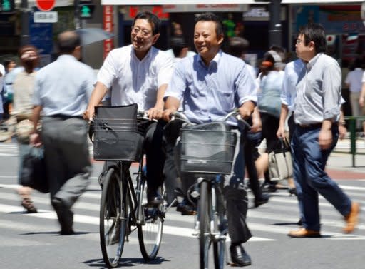 This file photo shows cyclists crossing a road in Tokyo, in July. Private consumption, which accounts for some 60 percent of the Japanese economy, expanded 0.1 percent in the three months to June, dropping steeply from a 1.2 percent expansion marked in the previous quarter