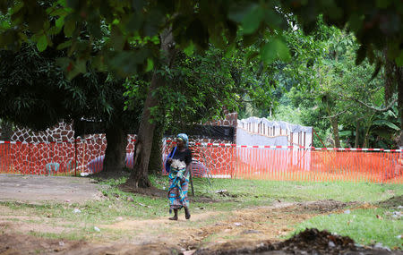 A resident walks near a cordon ribbon in the area, prepared to receive suspected Ebola cases, at the Mbandaka General Hospital, in Mbandaka, Democratic Republic of Congo May 20, 2018. REUTERS/Kenny Katombe