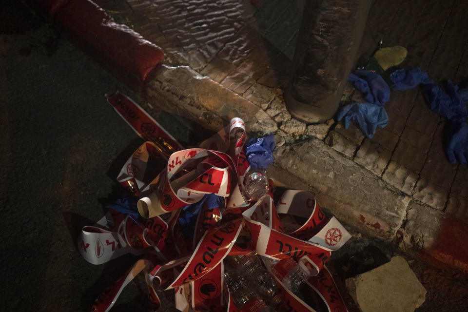 Police tape and gloves are discarded at the scene of a shooting attack that wounded several Israelis near the Old City of Jerusalem, early Sunday, Aug. 14, 2022. Israeli police and medics say a gunman opened fire at a bus in a suspected Palestinian attack that came a week after violence flared up between Israel and militants in Gaza. (AP Photo/ Maya Alleruzzo)