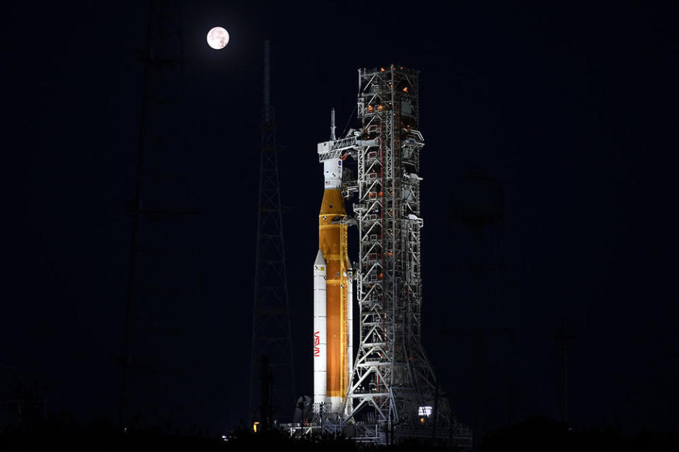 A full moon sets behind the Space Launch System rocket at pad 39B earlier this summer. / Credit: William Harwood/CBS News