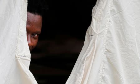 A Haitian refugee sticks his head out of the window from a tent set up from Canadian Armed Forces near the border in Lacolle, Quebec. Canada has deployed soldiers to erect tents near the U.S. border to temporarily house hundreds of asylum seekers crossing from New York state, officials said on Wednesday, an influx of mostly Haitians prompted by fear of deportation by the U.S. government. REUTERS/Christinne Muschi