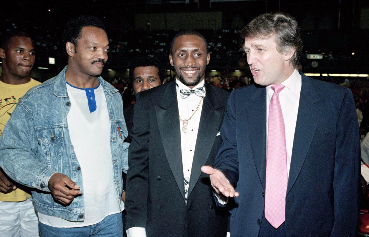 Donald Trump, right, gestures to Jesse Jackson, left, and Tommy Hearns, during ringside conversation prior to the Mike Tyson-Carl Williams fight in Atlantic City, N.J., on July 21, 1989.