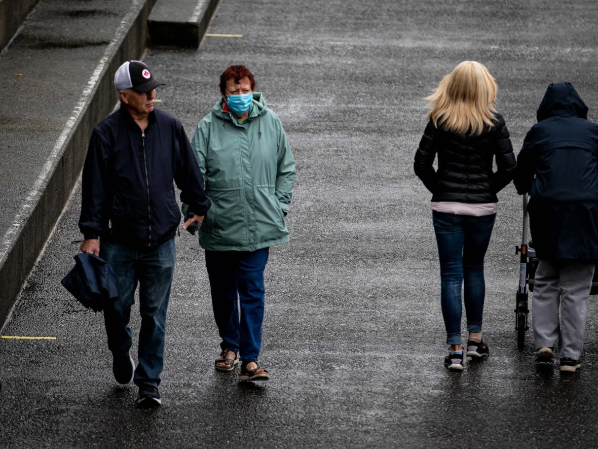 Pedestrians in Victoria on Oct. 19. Mask use will still be required in all public indoor settings, despite some restrictions being eased as of next Monday. (Ken Mizokoshi/CBC - image credit)