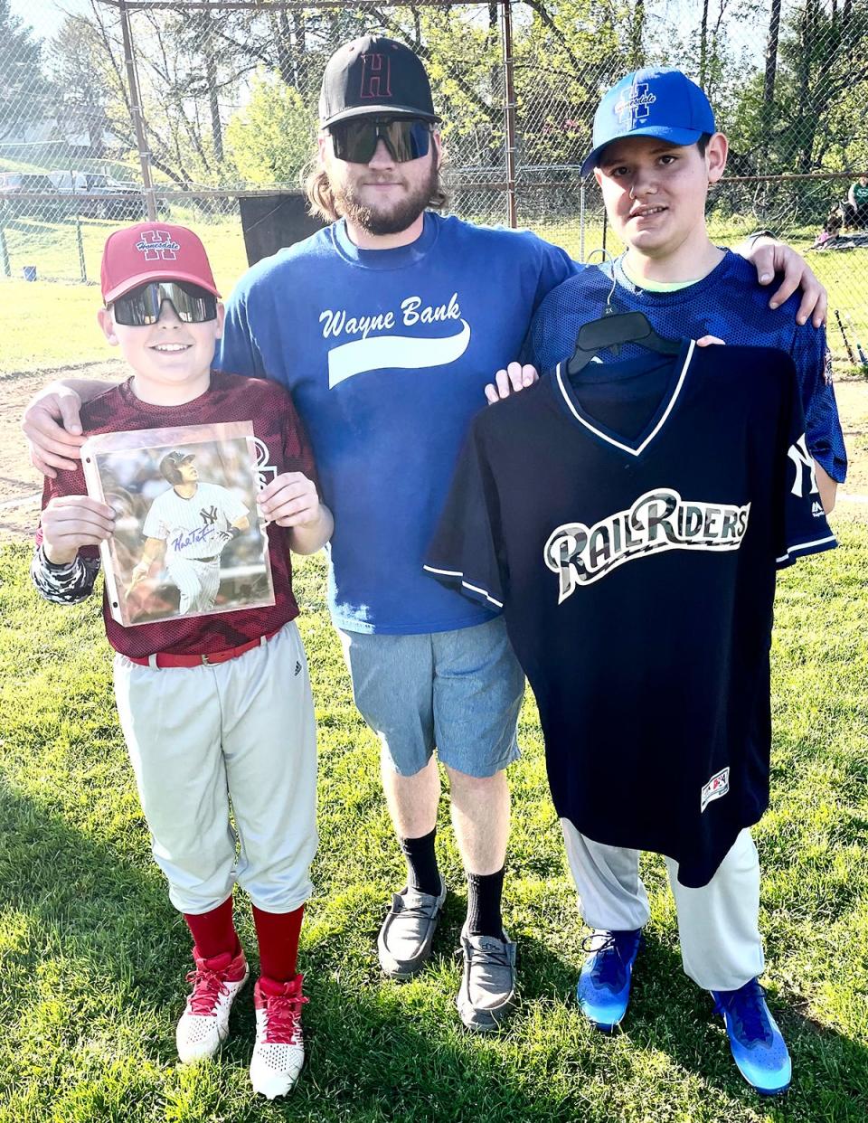 The Honesdale Little Baseball Association hosted Opening Day ceremonies for the 2023 season Monday night at Scott Kinzinger Memorial Complex. Pictured here is Wayne Bank Dodgers Manager Matt Abbott flanked by players Kaylem Kresge (left) and Tobiaz Smith (right). They're displaying items that are being raffled off as a fundraiser.
