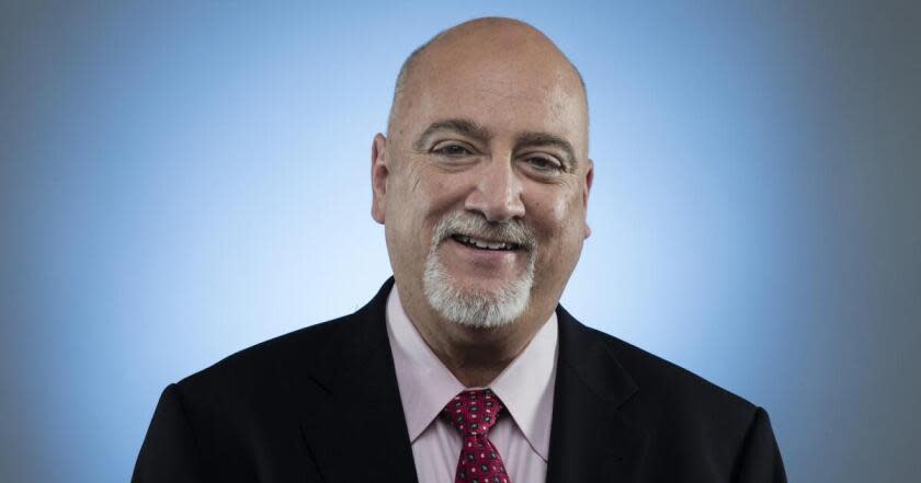 Los Angeles Times columnist Bill Plaschke sits and smiles for a portrait