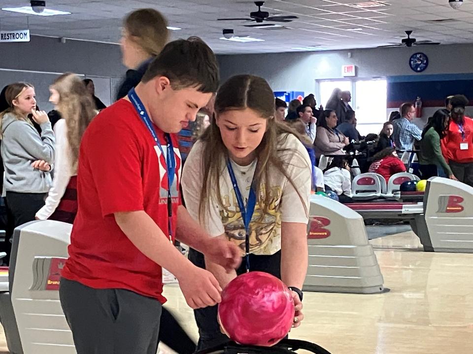 Cailynn Bailey, a junior at Plymouth High School, helps Mason Otterbacher bowl a frame Wednesday at Lex Lanes during an event for National Developmental Disabilities Awareness Month.