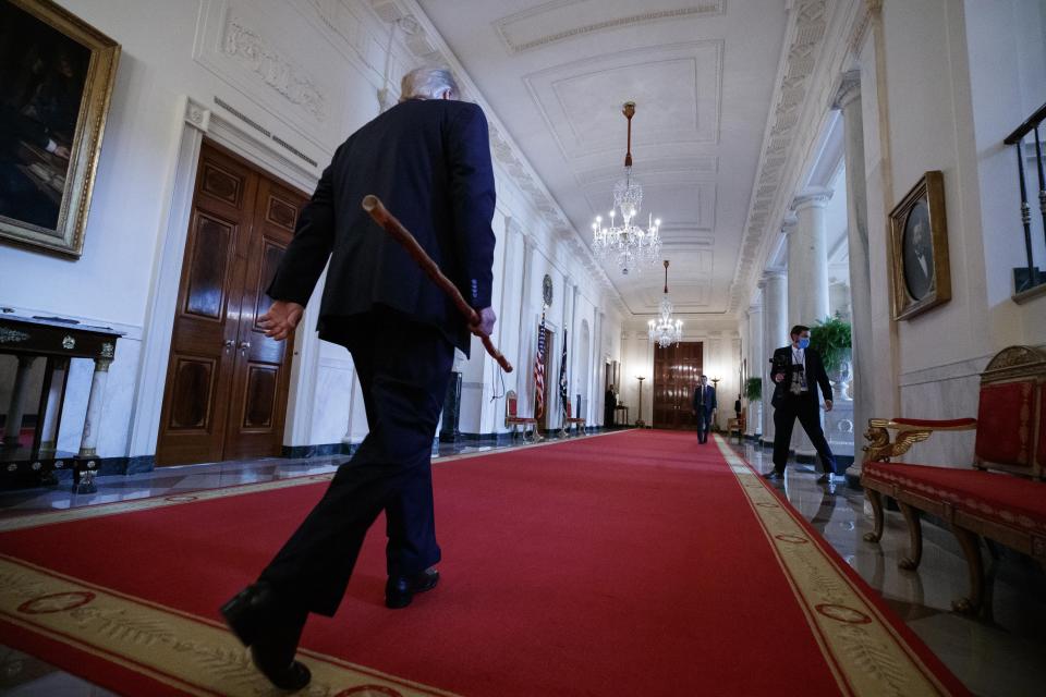 President Donald Trump departs carrying a walking stick given to him by Sen. Lamar Alexander, R-Tenn., after a signing ceremony for H.R. 1957 – "The Great American Outdoors Act," in the East Room of the White House, Tuesday, Aug. 4, 2020, in Washington. (AP Photo/Alex Brandon)