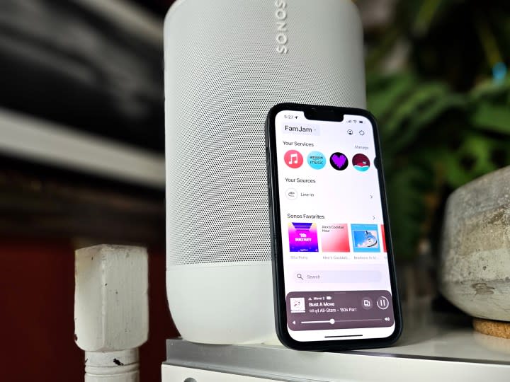 An iPhone displaying the new Sonos iOS app in front of a Sonos Move 2 speaker.