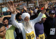 World's oldest marathon runner, 94 year old Fauja Singh (C) gestures before the start of a short version of 6 kilometers International Marathon in Lahore, 30 January 2005. Singh born in Indian Punjab and now residing in London, has the unique distinction of taking part in record six full marathons in London, besides competing in similar events in other parts of the world. AFP PHOTO/Arif ALI