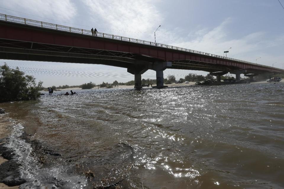 Water flows in a usually dry riverbed Wednesday, March 26, 2014, in San Luis Rio Colorado, Mexico. Colorado River water has begun pouring over a barren delta near the U.S.-Mexico border, the result of a landmark bi-national agreement being celebrated Thursday. (AP Photo/Gregory Bull)