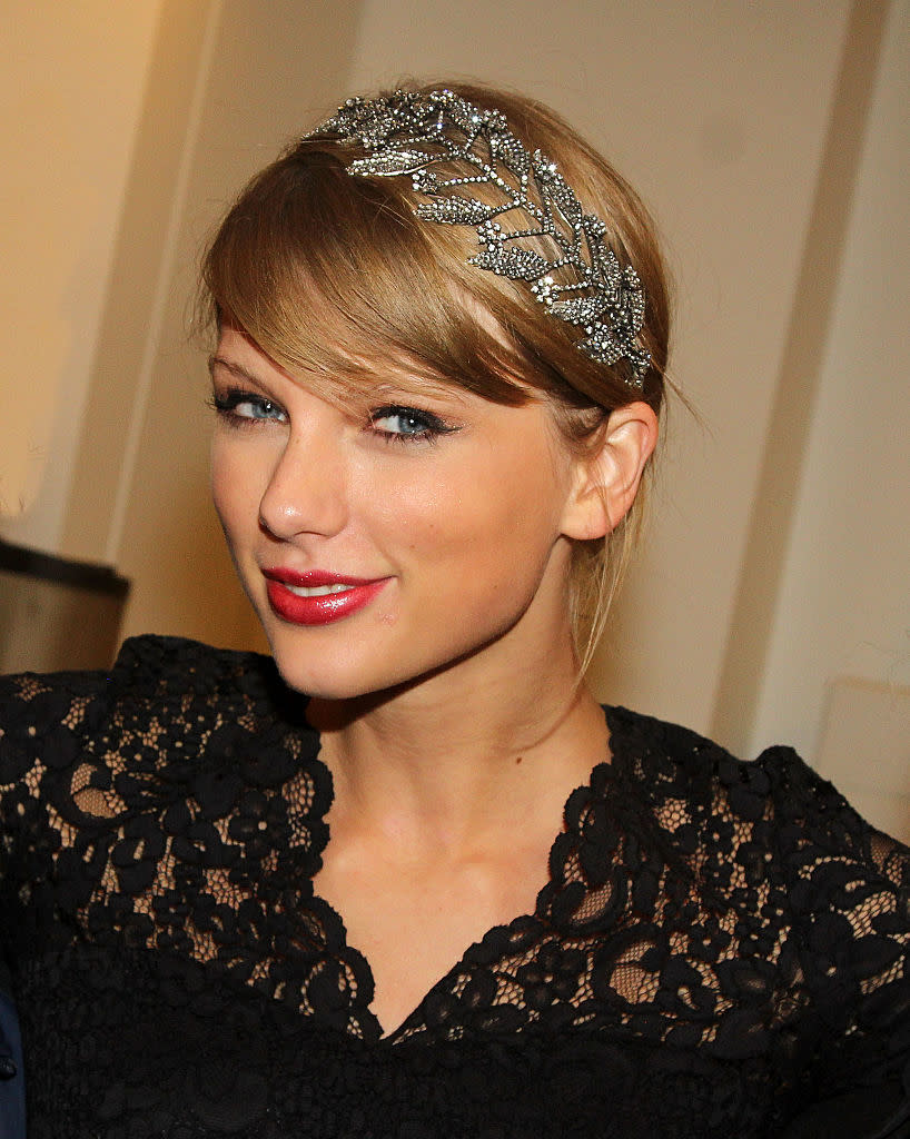 Woman in lace dress with bejeweled headband, smiling