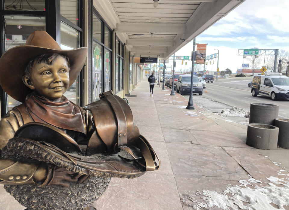 A sculpture of a boy with a saddle, seen Thursday, Dec. 15, 2022, on a street in downtown Cheyenne, Wyo. is a nod to the state's Western heritage. Wyoming has sought with several new laws to attract crypto-related businesses to the state and plans to keep doing so despite the industry's recent troubles. (AP Photo/Mead Gruver)