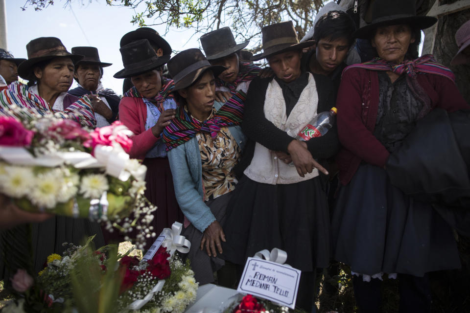 En imagen del 15 de agosto de 2018, los familiares de personas que murieron a manos de las guerrillas del grupo Sendero Luminoso y el ejército peruano en la década de 1980 observan los restos de sus seres queridos, antes del entierro en el cementerio en Quinuas, en la provincia de Ayacucho. Científicos forenses en varios países de Latinoamérica siguen trabajando para identificar los restos de las personas que fueron asesinadas durante dictaduras militares y conflictos civiles registrados hace décadas. (AP Foto/Rodrigo Abd)