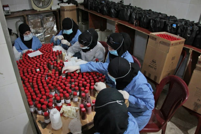 Women fill bottles of medicine in Douma, a rebel-held town in the Eastern Ghouta region near the Syrian capital where medics are improvising to cope with shortages