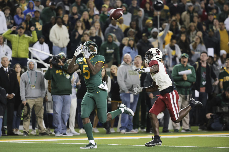 Baylor wide receiver Denzel Mims, left, waits the ball on a 30-yard touchdown catch as Oklahoma cornerback Jaden Davis, right, defends during the first half of an NCAA college football game in Waco, Texas, Saturday, Nov. 16, 2019. (AP Photo/Ray Carlin)