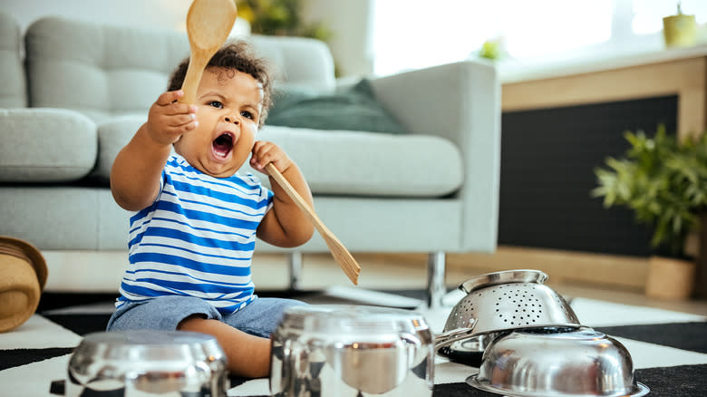 child playing with wood spoon