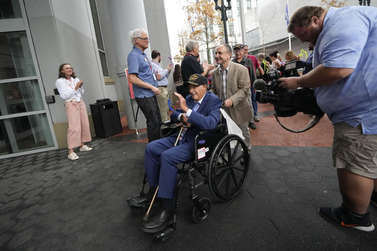 World War II veteran Joseph Eskenazi, who at 104 years and 11 months old is the oldest living veteran to survive the attack on Pearl Harbor, is greeted as he arrives at the National World War II Museum to celebrate his upcoming 105th birthday in New Orleans, Wednesday, Jan. 11, 2023. (AP Photo/Gerald Herbert)