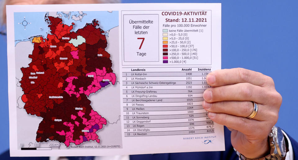 A map of Germany showing the spread of Covid in the country held up by Robert Koch Institute President Lothar Wieler.