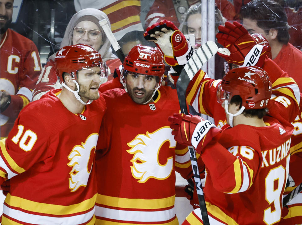 Calgary Flames forward Nazem Kadri (91) celebrates his goal with teammates during the third period of an NHL hockey game against the Arizona Coyotes in Calgary, Alberta, Sunday, April 14, 2024. (Jeff McIntosh/The Canadian Press via AP)