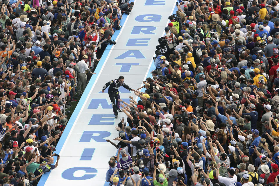 Jimmie Johnson greets fans during driver introductions before the NASCAR Daytona 500 auto race at Daytona International Speedway, Sunday, Feb. 16, 2020, in Daytona Beach, Fla. (AP Photo/David Graham)