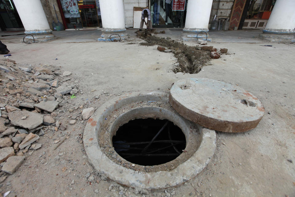 En esta fotografía del 10 de septiembre de 2010, una persona trabaja cerca de una alcantarilla en el centro de Nueva Delhi, India. (AP Foto/Saurabh Das, Archivo)