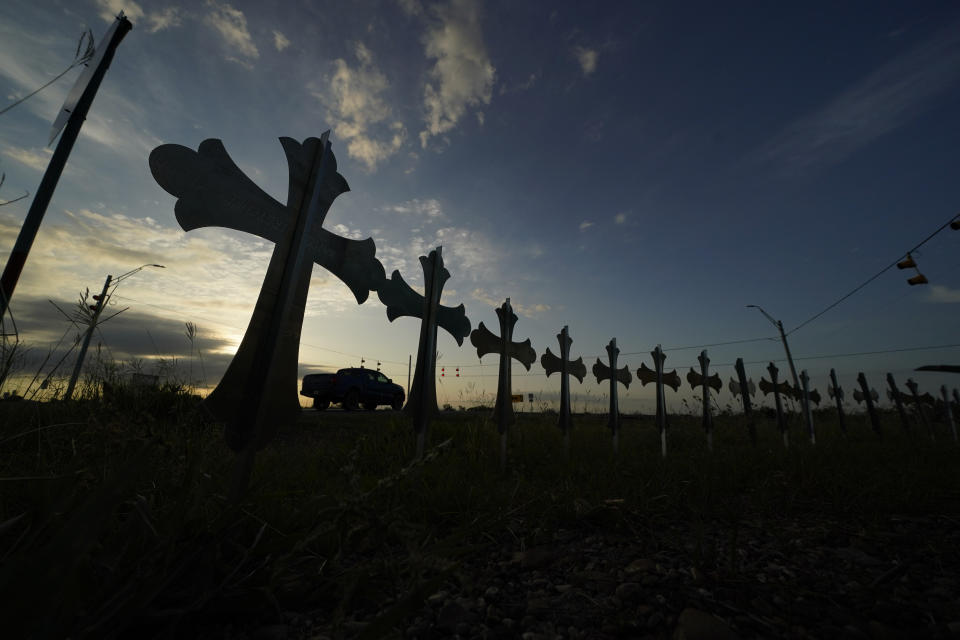 A truck passes crosses placed to honor the victims killed in last week's shooting at Robb Elementary School, Friday, June 3, 2022, in Uvalde, Texas. (AP Photo/Eric Gay)