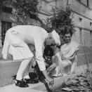 28th October 1950: Indian Prime Minister Pandit Jawaharlal Nehru (1889 - 1964) by a lily pond in the garden of his New Delhi home. WIth him are his daughter Indira Gandhi (born Indira Priyardarshini Nehru, 1917 - 1984), and her son Rajiv (1944 - 1991), who both succeeded him as Prime Minister of India. Original Publication: Picture Post - 5141 - A Voice Above The Battle - pub. 1950 (Photo by Bert Hardy/Picture Post/Hulton Archive/Getty Images)