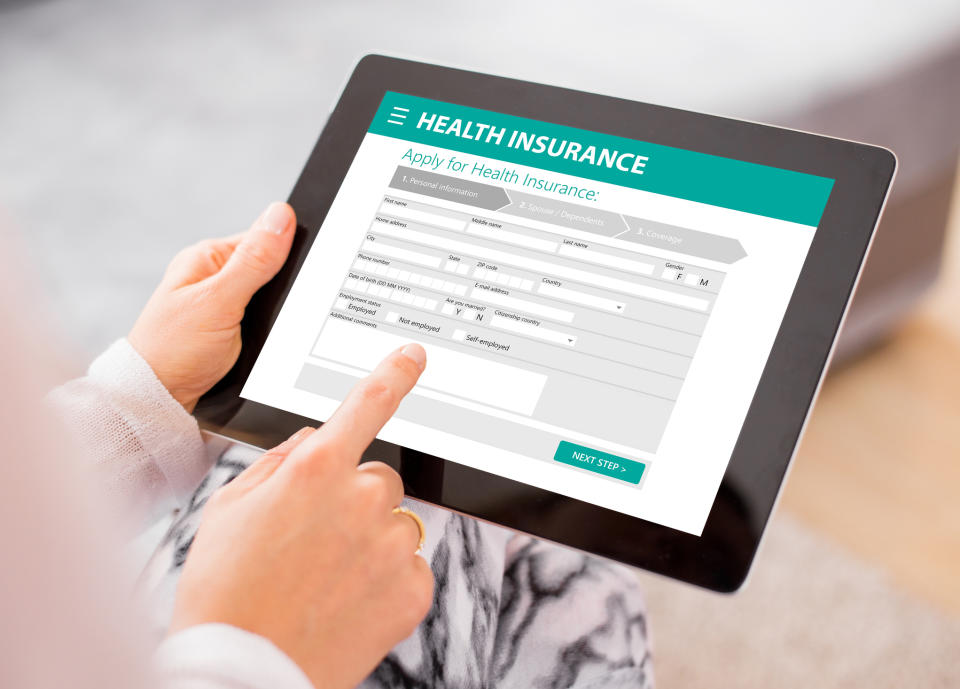 Person holding a tablet with an online health insurance application