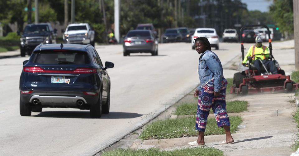 Daytona Beach's Mason Avenue is poised to get $8.9 million in upgrades including resurfacing, new sections of sidewalk, new traffic signal mast arms and raised pedestrian crossings with nighttime safety lights. Pictured is a woman watching oncoming traffic before darting across Mason Avenue east of Clyde Morris Boulevard in August.
