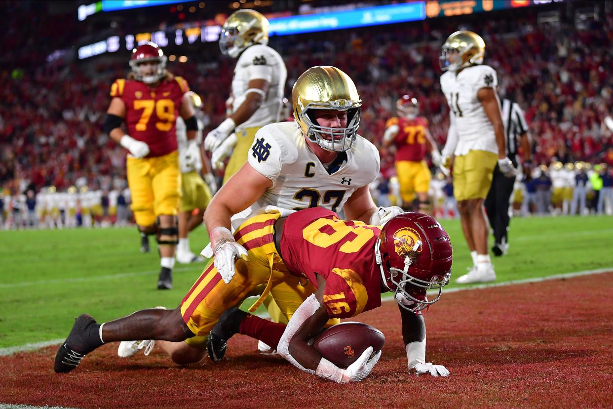 Nov 26, 2022; Los Angeles, California, USA; Southern California Trojans wide receiver Tahj Washington (16) scores a touchdown against Notre Dame Fighting Irish linebacker JD Bertrand (27) during the first half at the Los Angeles Memorial Coliseum. Mandatory Credit: Gary A. Vasquez-USA TODAY Sports