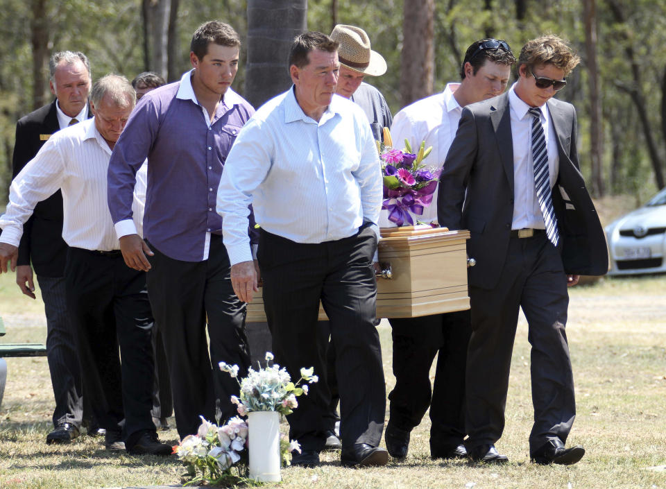 In this Jan. 20, 2014 photo mad available on Feb. 5, 2014, family and friends carry a casket at the funeral of Noelene and Yvana Bischoff at the Gatton Baptist Church in Gatton, Australia. Bischoff and her teenage daughter who became ill and died within hours of each other while on vacation on the tourist island of Bali were probably killed by a form of food poisoning, a relative said Wednesday, Feb. 5, 2014. (AP Photo/Tertius Pickard)