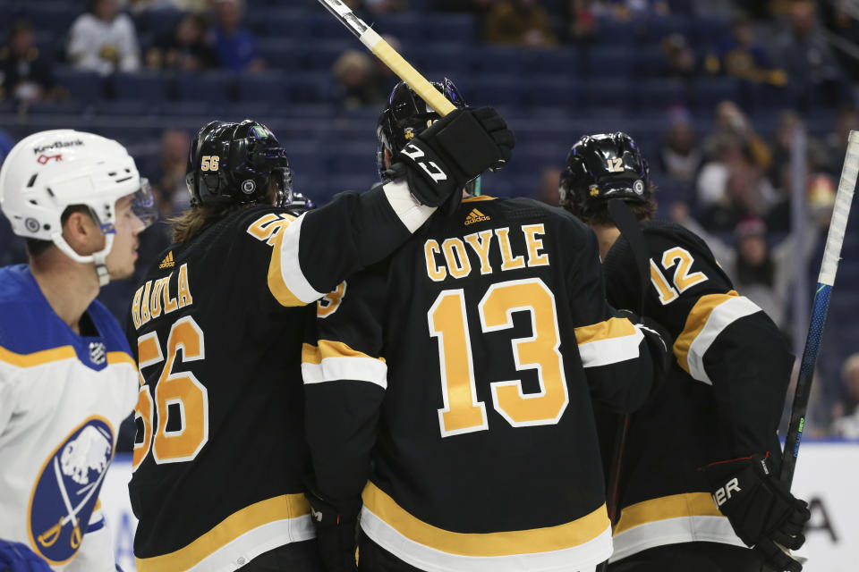 Boston Bruins center Charlie Coyle (13) celebrates with teammates Erik Haula (56) and Craig Smith (12) after his goal during the second period of an NHL hockey game against the Buffalo Sabres, Friday, Oct. 22, 2021, in Buffalo, N.Y. (AP Photo/Joshua Bessex)