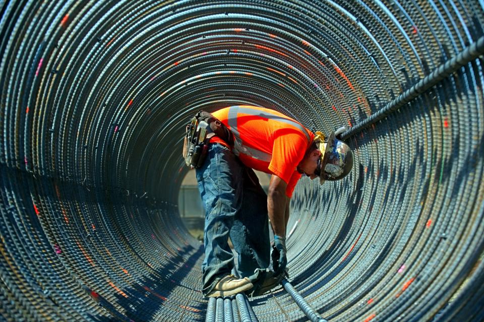 Construction worker Fernando Mendoza with the Concord-based Conco is caught up in the concentric rings of a 58-ft- long rebar support structure as he works to assemble it for the west extension of the Crosstown Freeway in the Boggs Tract area of Stockton. The concentric rings of the column help to draw the viewers' eyes to Mendoza.