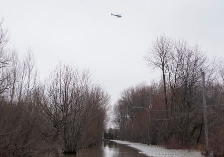 A helicopter flies over the flooded region of Rigaud, Quebec, Canada April 21, 2019. REUTERS/Christinne Muschi