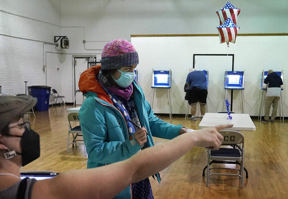 Monica Rojas gets directions from a poll worker on her way to casting her ballot at Sabathani Community Center during municipal elections Tuesday, Nov. 2, 2021, in Minneapolis. Voters in Minneapolis are deciding whether to replace the city’s police department with a new Department of Public Safety. The election comes more than a year after George Floyd’s death launched a movement to defund or abolish police across the country.(David Joles /Star Tribune via AP)