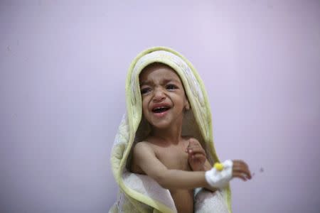 A malnourished boy cries as he sits on a bed at a malnutrition intensive care unit in Yemen's capital Sanaa February 10, 2016. REUTERS/Khaled Abdullah