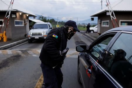 A member of the Community Police talks to a driver at a checkpoint in the indigenous Purepecha town of Cheran, in Michoacan state, Mexico June 28, 2018. Picture taken June 28, 2018. REUTERS/Alan Ortega