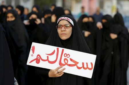 A protester holds a banner saying "to hell with you" as she takes part in a protest against the execution of Saudi Shi'ite cleric Nimr al-Nimr by Saudi authorities, in the village of Sanabis, west of Manama, Bahrain January 2, 2016. REUTERS/Hamad I Mohammed