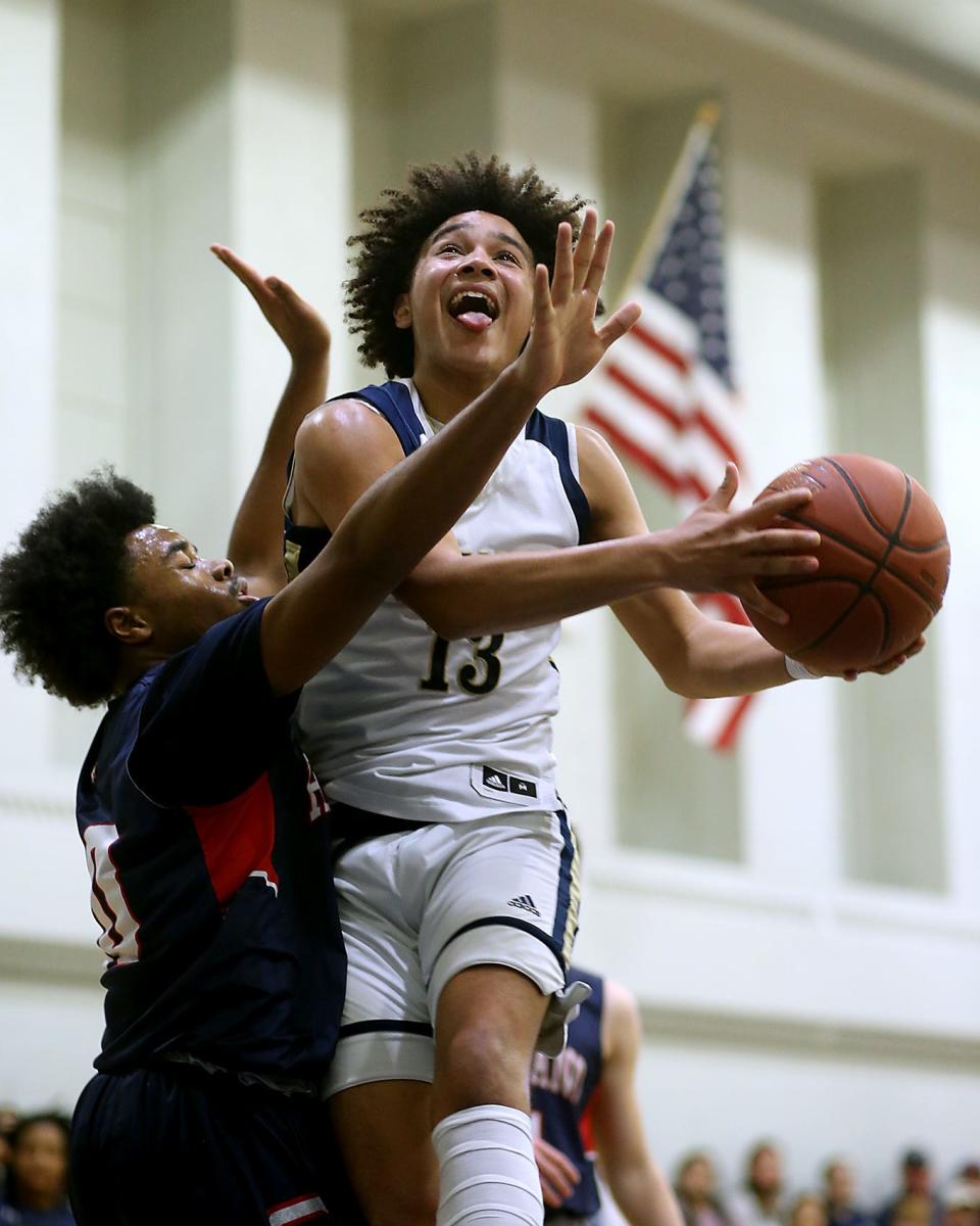 Archbishop William's Tristan Rodriguez makes a move to avoid Rockland's Daniel Johnson and hit a layup during second quarter action of their game against Rockland in the Round of 32 game in the Division 3 state tournament at Archbishop Williams High School in Braintree on Friday, March 3, 2023.