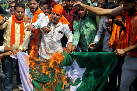 Demonstrators react as they burn Pakistan’s national flag during a protest organised by activists of Bajrang Dal, a Hindu hardline group, in Jammu, against Sunday's attack at an Indian army base camp in Kashmir's Uri, September 20, 2016. REUTERS/Mukesh Gupta