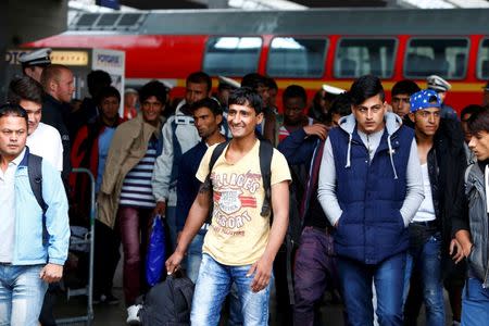 Migrants smile after arriving by train at the main railway station in Munich, Germany September 7, 2015. REUTERS/Michaela Rehle