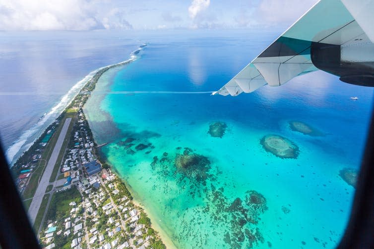 <span class="caption">An aerial view of Funafuti atoll, Tuvalu, shows the airstrip of Vaiaku international airport. There is little space for the coast to retreat as sea levels rise.</span> <span class="attribution"><a class="link " href="https://www.shutterstock.com/image-photo/tuvalu-under-wing-airplane-aerial-view-1221046468" rel="nofollow noopener" target="_blank" data-ylk="slk:Maloff/Shutterstock;elm:context_link;itc:0;sec:content-canvas">Maloff/Shutterstock</a></span>