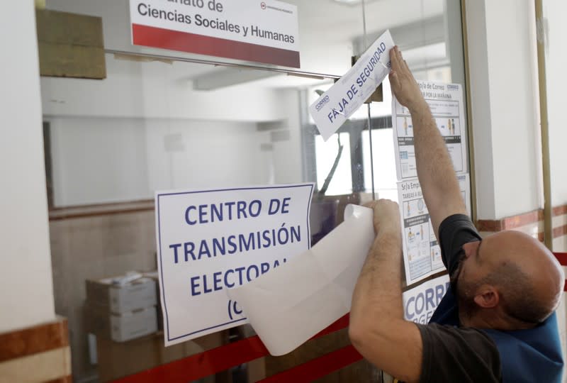 An Argentine mail service worker seals an office containing ballot boxes at a school, which will serve as a polling station, one day ahead of presidential elections in Buenos Aires