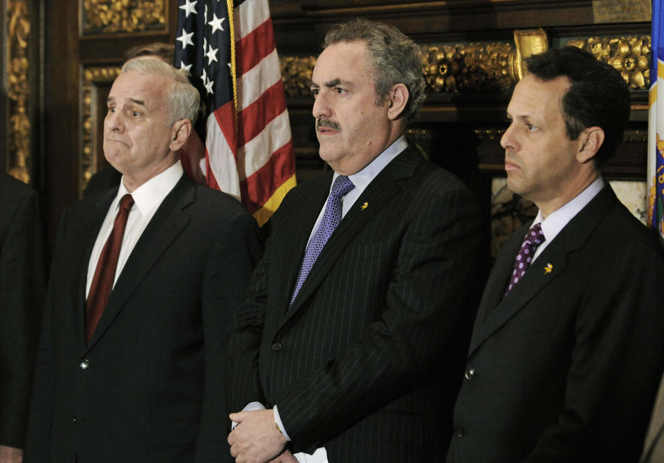 Minnesota Gov. Mark Dayton, left, and Minnesota Vikings NFL football owners Zygi Wilf, center, and his brother Mark listen during a news conference Thursday, March 1, 2012 in St. Paul , Minn. where it was announced that a site for a new Vikings football stadium along with a financing agreement had been reached. (AP Photo/Jim Mone)