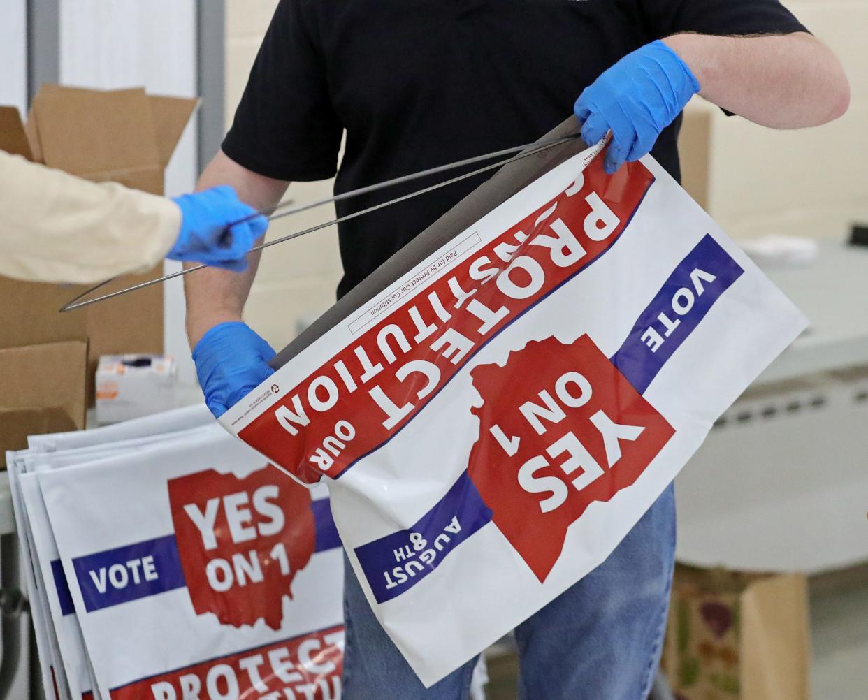 Workers assemble signs supporting Issue 1 before a Geauga County GOP Central Committee meeting in Chesterland on July 19.