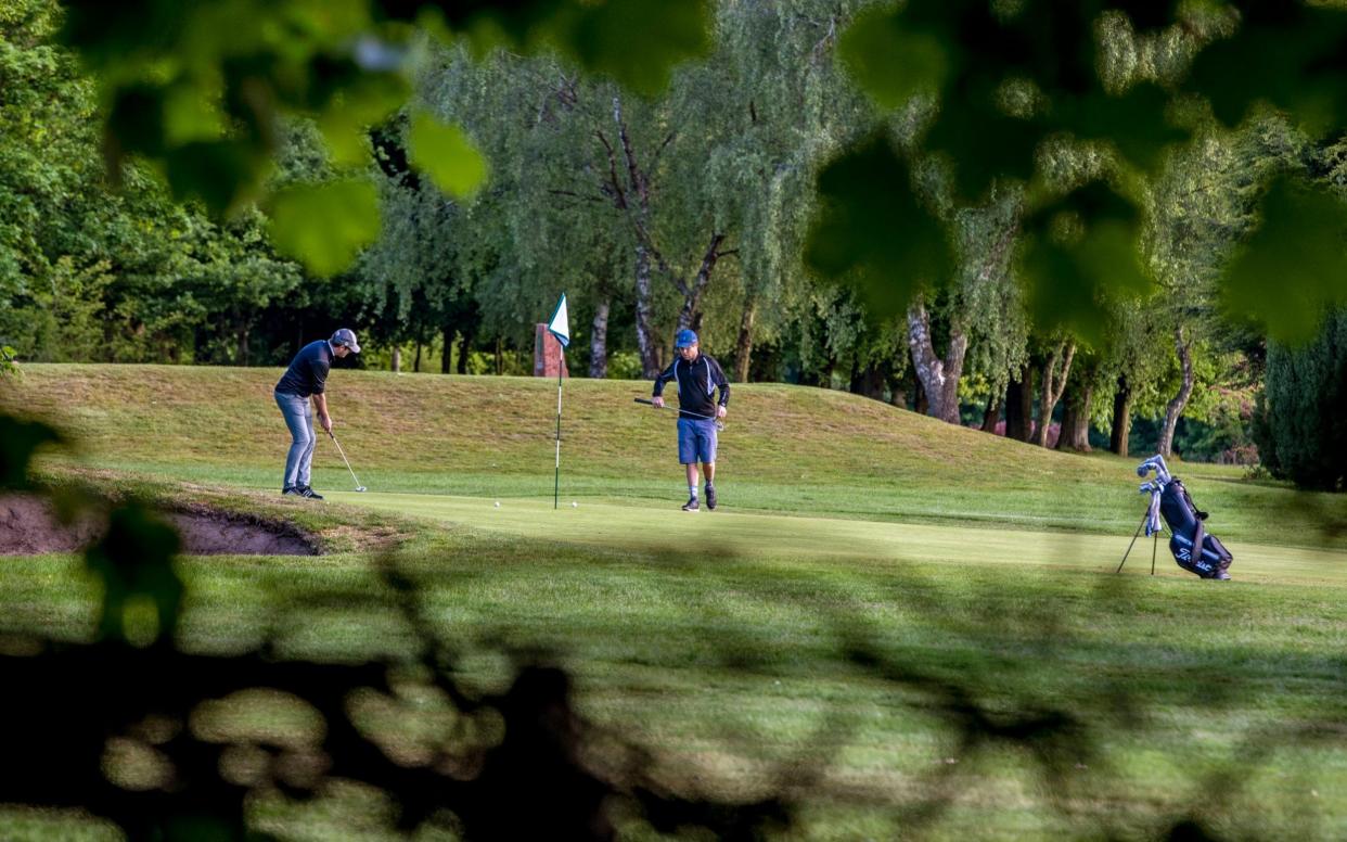 Golfers putt on the 9th green at Allerton Manor golf course in Liverpool after the lifting of lockdown restrictions  - PA