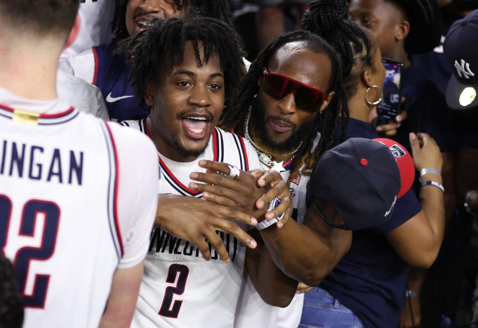 Packers running back Aaron Jones celebrates with his cousin, UConn senior Tristen Newton, after the Huskies defeated the San Diego State Aztecs, 76-59, during the NCAA men's basketball national championship game Monday at NRG Stadium in Houston. Newton scored a game-high 19 points.